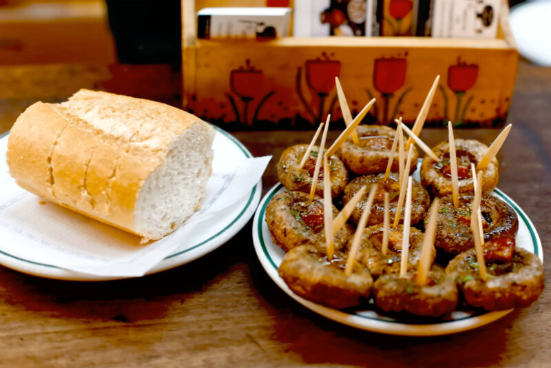 Garlic-stuffed mushrooms and bread on a wooden table