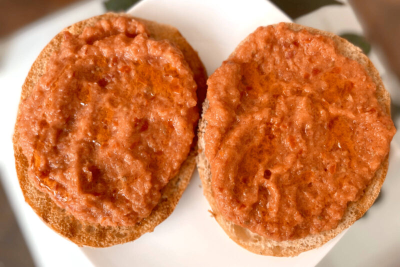 Toast with tomato spread, one of the simplest and tastiest vegan tapas in Spain, on a white plate