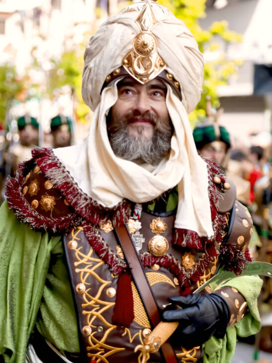 A man dressed in colorful Moorish clothes at a Moros y Cristianos parade in Alcoy
